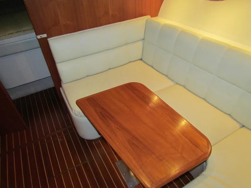 Slide: The Image of Interior of 1999 Tiara Yachts 3500 Open with wooden table and white seating. - 40