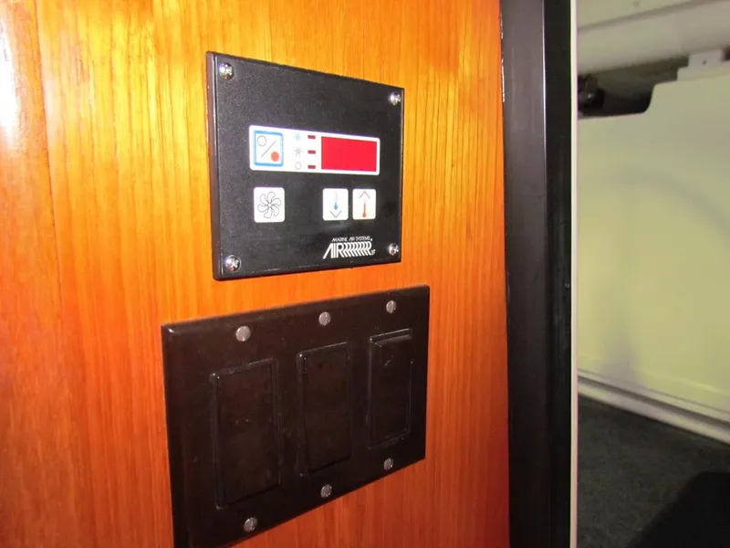 Slide: The Image of Control panel on a 1999 Tiara Yachts 3500 Open, mounted on a wooden surface. - 41