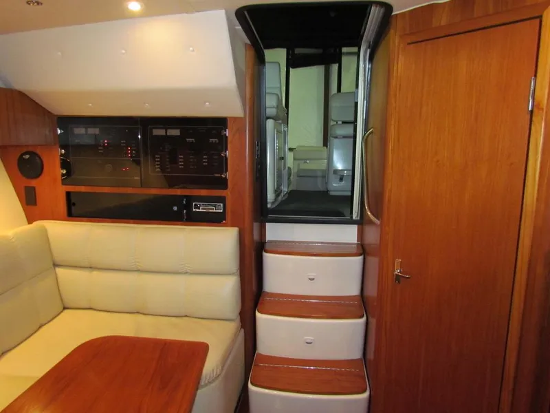 Slide: The Image of 1999 Tiara Yachts 3500 Open interior with wooden stairs, seating, and control panels. - 44