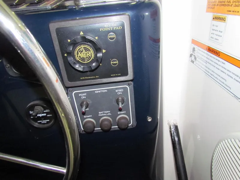 Slide: The Image of Control panel of a 1999 Tiara Yachts 3500 Open with ignition switches and warning labels. - 46