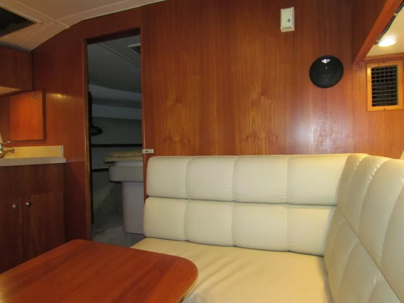 Slide: The Image of Interior of 1999 Tiara Yachts 3500 Open with wood paneling and white seating. - 49