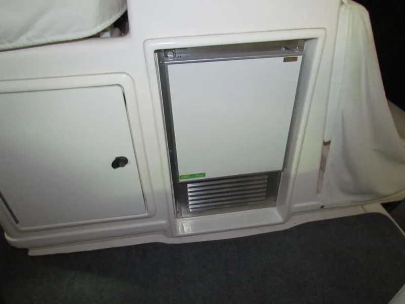 Slide: The Image of 1999 Tiara Yachts 3500 Open interior with built-in refrigerator and storage compartment. - 9