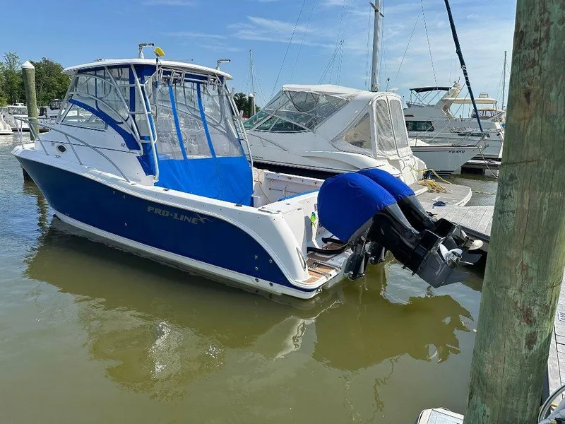 Slide: The Image of 2006 Pro-Line 32 Express boat docked at marina, featuring blue and white design. - 3