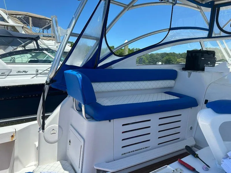 Slide: The Image of 2006 Pro-Line 32 Express boat interior with blue and white seating, docked near other boats. - 5