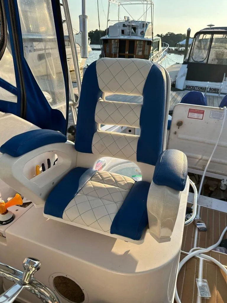 Slide: The Image of Captain's chair on 2006 Pro-Line 32 Express boat, featuring blue and white upholstery. - 6