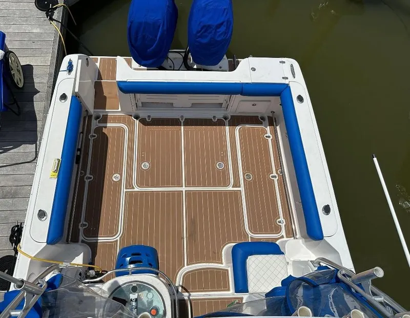 Slide: The Image of 2006 Pro-Line 32 Express boat deck with blue seating and wood-patterned flooring. - 7