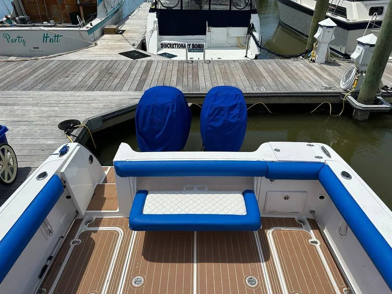 Slide: The Image of 2006 Pro-Line 32 Express boat with blue seating and covered engines at a dock. - 8