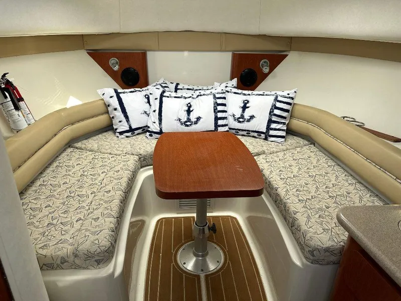 Slide: The Image of 2006 Pro-Line 32 Express cabin interior with anchor-themed pillows and wooden table. - 9