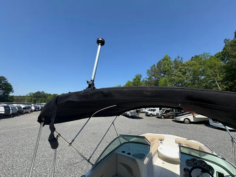 Slide: The Image of 2017 NauticStar 203 DC boat with black bimini top in a parking lot. - 12