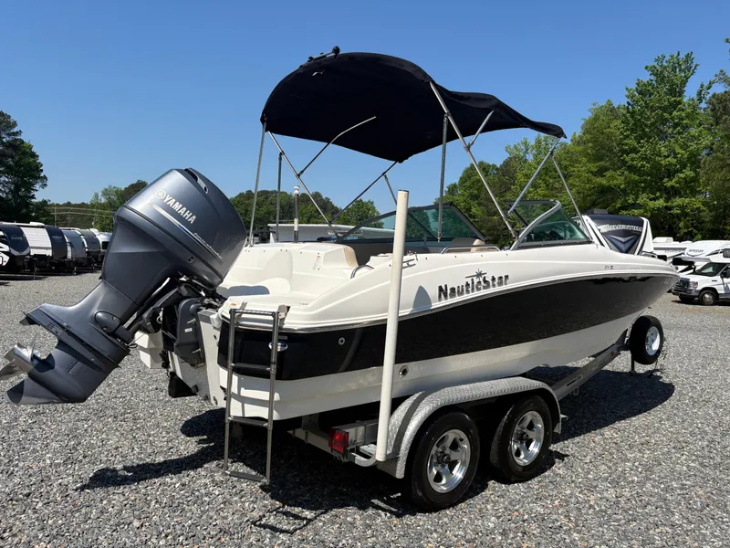 Slide: The Image of 2017 NauticStar 203 DC boat with Yamaha engine on a trailer, parked outdoors. - 5