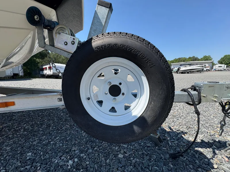 Slide: The Image of Trailer tire for 2017 NauticStar 203 DC boat on gravel lot. - 7