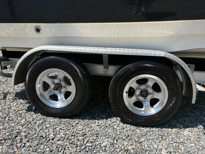 Slide: The Image of Trailer wheels of a 2017 NauticStar 203 DC boat on gravel surface. - 8