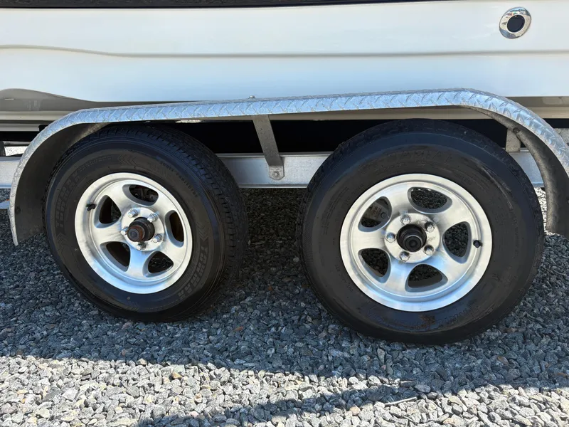 Slide: The Image of Trailer wheels of a 2017 NauticStar 203 DC boat on gravel surface. - 9