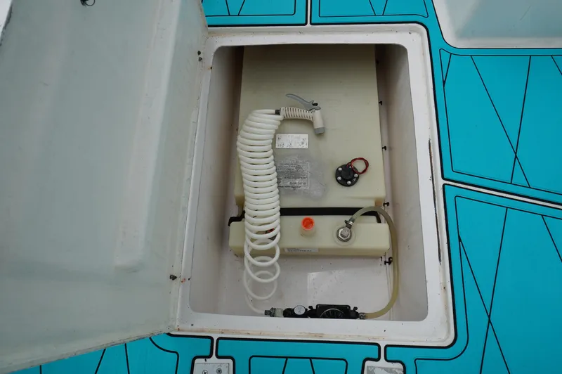 Slide: The Image of 1994 Wellcraft 30 Scarab Sport boat compartment with coiled hose and equipment. - 15