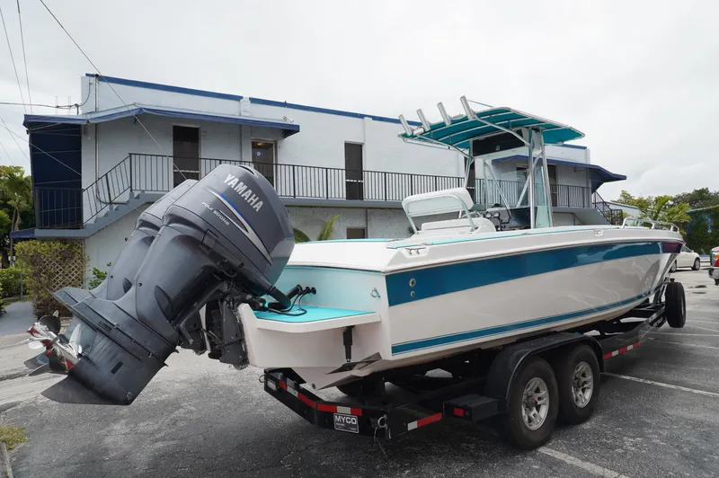 Slide: The Image of 1994 Wellcraft 30 Scarab Sport boat on trailer, parked near a building. - 2