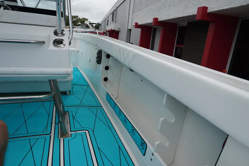Slide: The Image of 1994 Wellcraft 30 Scarab Sport boat interior with blue flooring and white railing. - 8