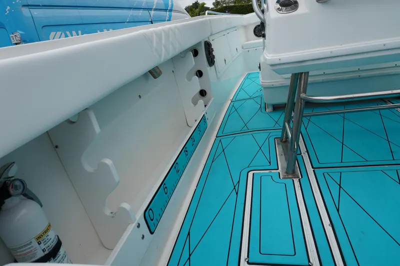 Slide: The Image of 1994 Wellcraft 30 Scarab Sport boat interior with blue deck and storage compartments. - 9