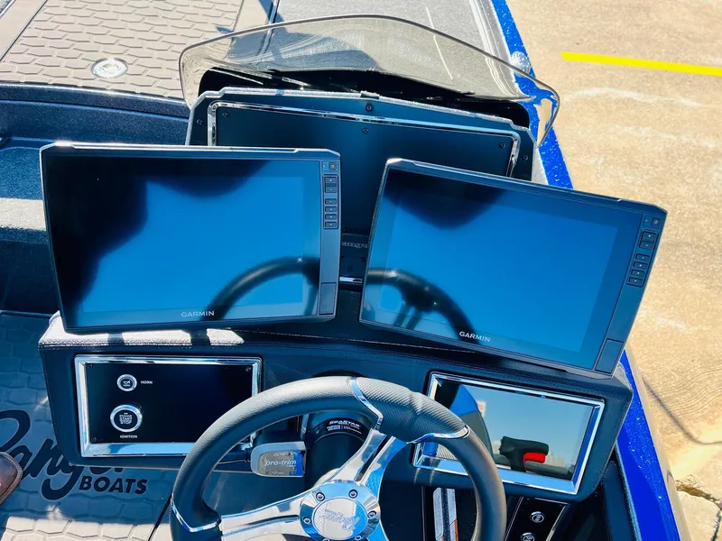 Slide: The Image of 2025 Ranger Z520R Cup-Equipped boat dashboard with multiple Garmin screens and steering wheel. - 34