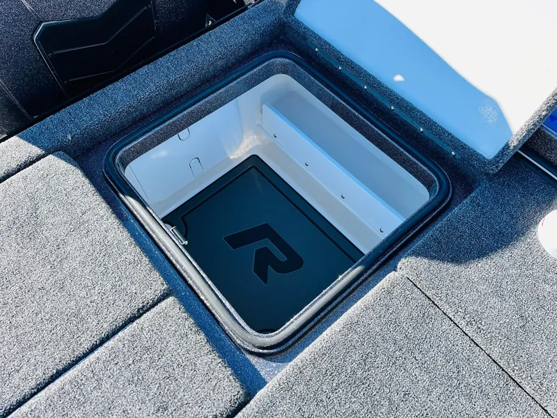 Slide: The Image of 2025 Ranger Z520R Cup-Equipped boat storage compartment with logo, open lid, and carpeted surface. - 47
