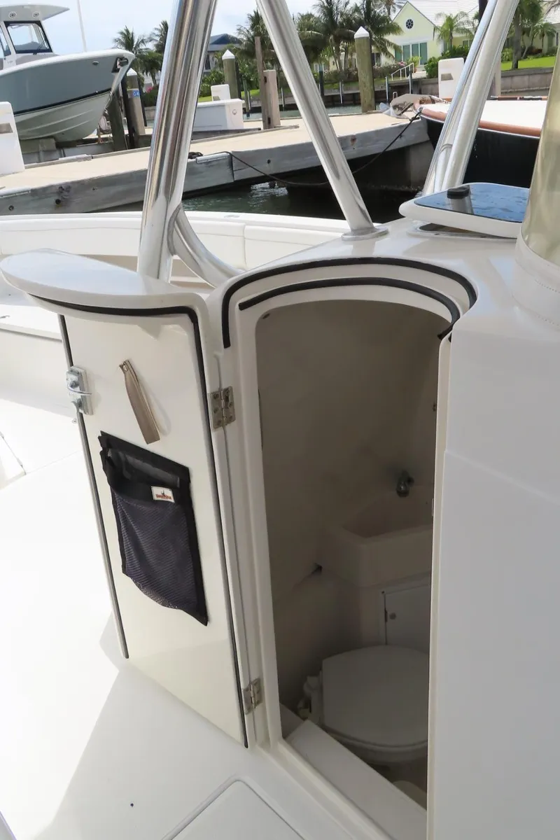 Slide: The Image of 2013 Jupiter 34 boat with open cabin door revealing interior storage space. - 14