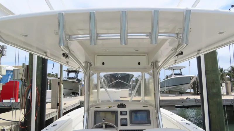 Slide: The Image of 2013 Jupiter 34 boat console with T-top and navigation equipment at a marina. - 17