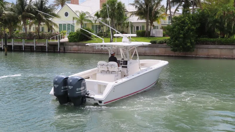 Slide: The Image of 2013 Jupiter 34 boat cruising near waterfront homes with twin engines. - 25