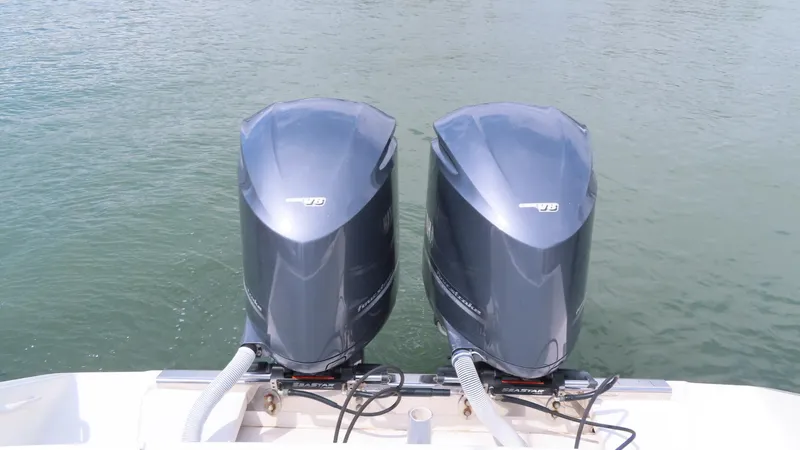 Slide: The Image of Twin outboard motors on a 2013 Jupiter 34 boat, floating on calm water. - 26