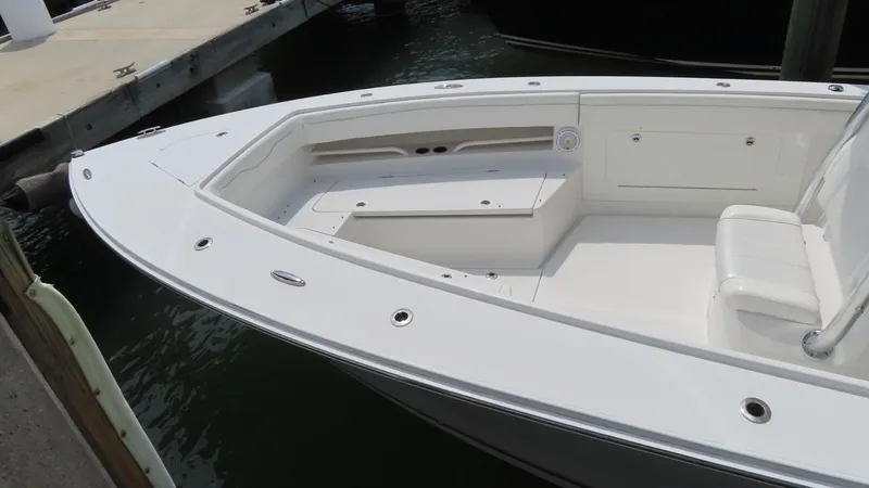 Slide: The Image of 2013 Jupiter 34 boat docked, showcasing spacious white deck and seating area. - 8
