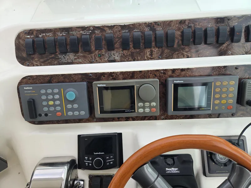 Slide: The Image of Control panel of a 1998 Sea Ray 400 Sundancer with navigation instruments and switches. - 11