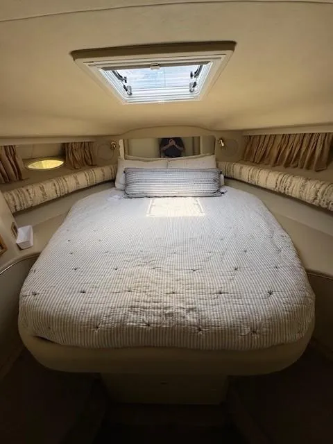 Slide: The Image of 1998 Sea Ray 400 Sundancer cabin with cozy bed and natural light from skylight. - 16