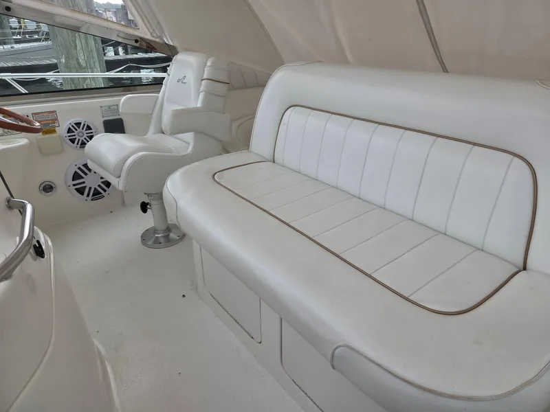 Slide: The Image of 1998 Sea Ray 400 Sundancer interior with white seating and helm chair. - 18