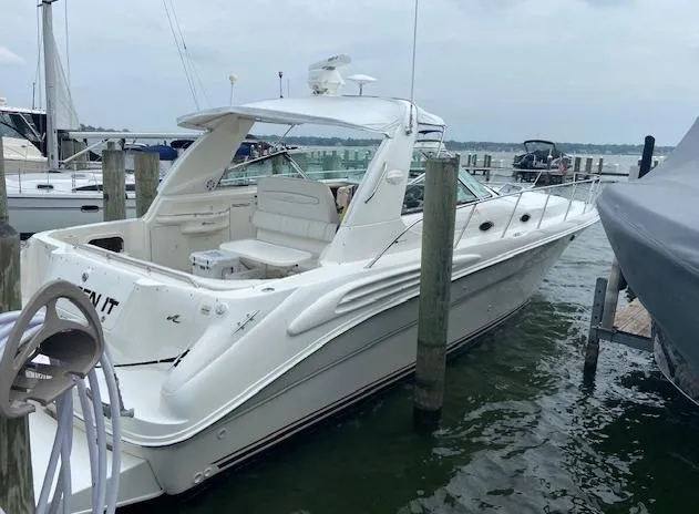 Slide: The Image of 1998 Sea Ray 400 Sundancer docked at a marina, showcasing sleek design and spacious deck. - 2