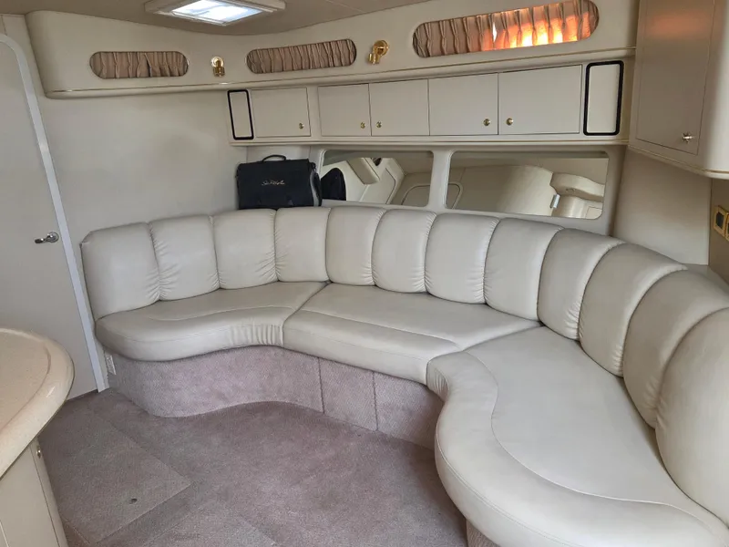 Slide: The Image of Interior of a 1998 Sea Ray 400 Sundancer with beige leather seating and cabinetry. - 25