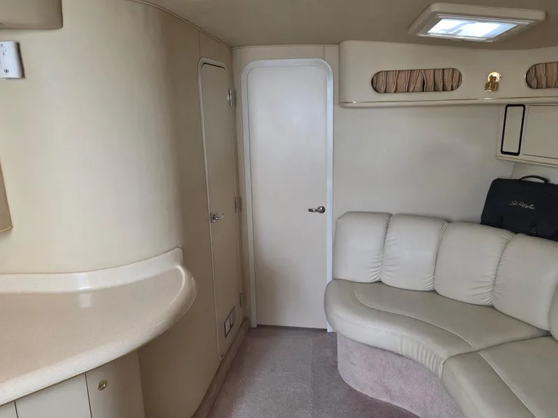 Slide: The Image of Interior of 1998 Sea Ray 400 Sundancer with beige seating and cabinetry. - 26