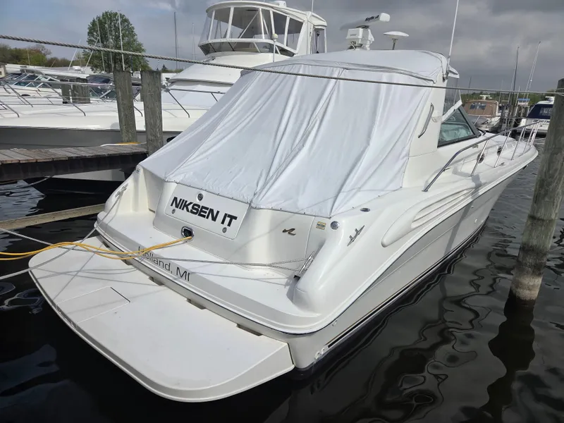 Slide: The Image of 1998 Sea Ray 400 Sundancer docked, covered with a white tarp, rear view. - 3