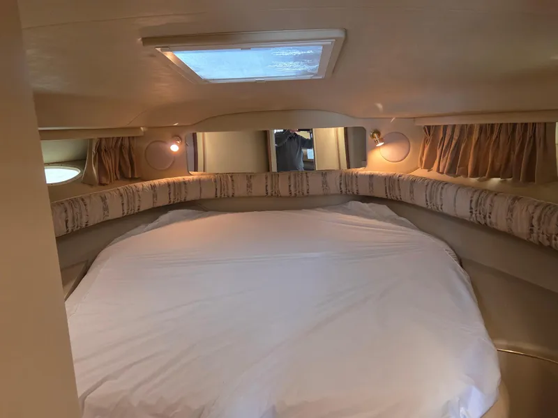 Slide: The Image of 1998 Sea Ray 400 Sundancer cabin interior with cozy bed and ambient lighting. - 32