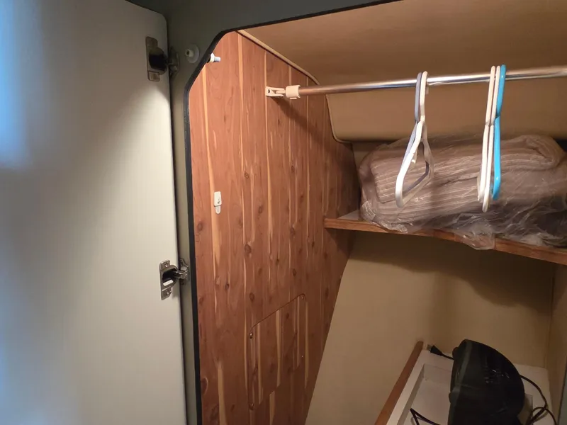 Slide: The Image of 1998 Sea Ray 400 Sundancer closet interior with wooden paneling and hangers. - 34