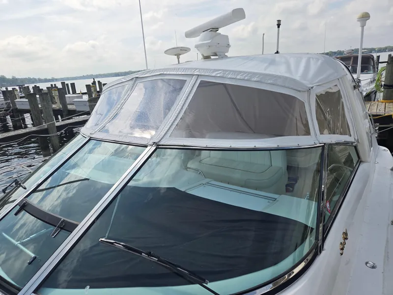 Slide: The Image of 1998 Sea Ray 400 Sundancer yacht docked, featuring sleek design and covered cockpit. - 4