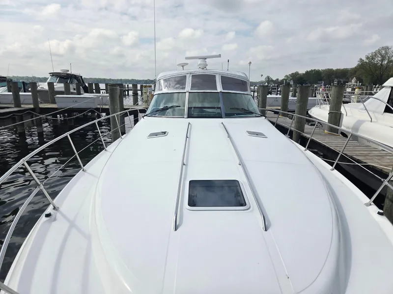 Slide: The Image of 1998 Sea Ray 400 Sundancer yacht docked at marina under cloudy sky. - 5