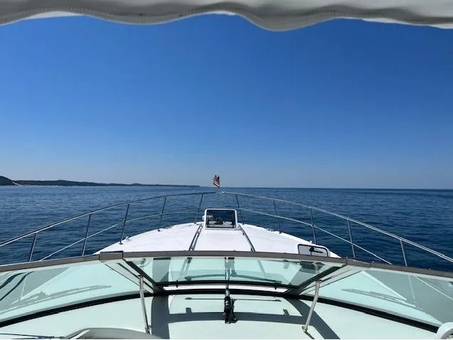 Slide: The Image of 1997 Sea Ray 400 Sundancer cruising on open water under clear blue skies. - 6