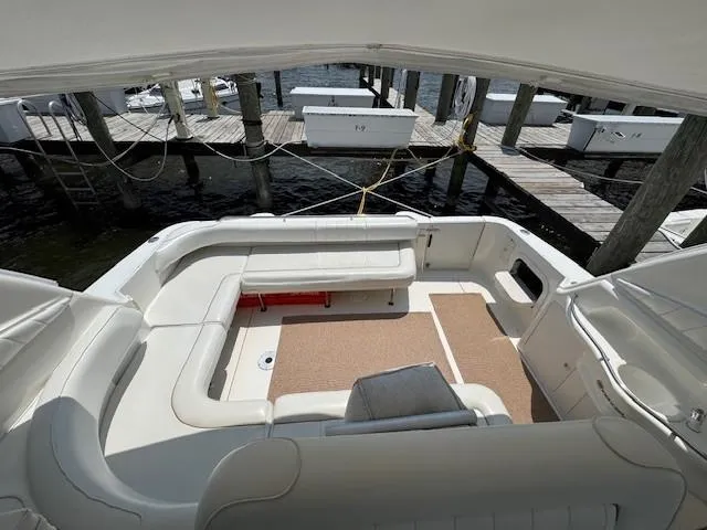 Slide: The Image of 1998 Sea Ray 400 Sundancer yacht interior with white seating and dock view. - 8