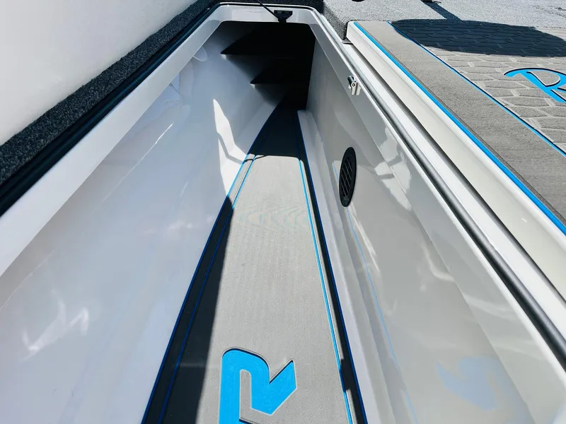 Slide: The Image of 2025 Ranger Z521R Cup-Equipped boat interior with sleek storage compartment and blue accents. - 21