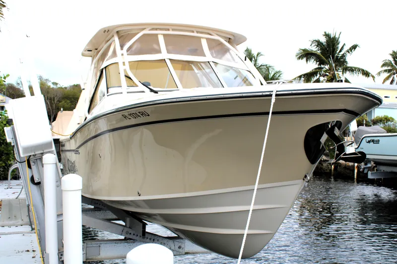 Slide: The Image of 2019 Grady-White Freedom 275 boat docked near palm trees. - 1