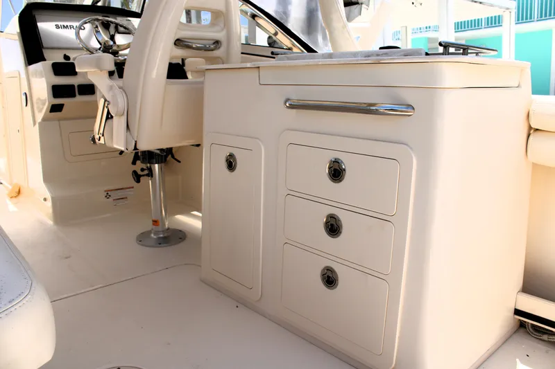 Slide: The Image of 2019 Grady-White Freedom 275 boat interior with storage drawers and helm seat. - 24