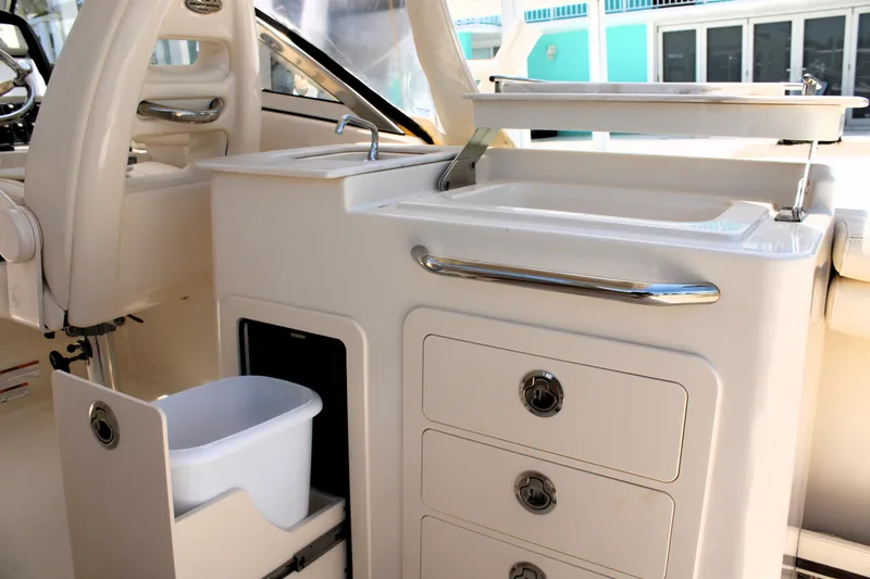 Slide: The Image of 2019 Grady-White Freedom 275 boat interior with sink, storage drawers, and trash bin. - 25