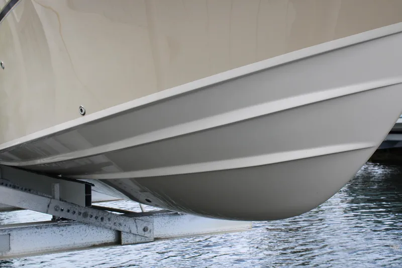 Slide: The Image of 2019 Grady-White Freedom 275 boat hull on lift above water. - 3