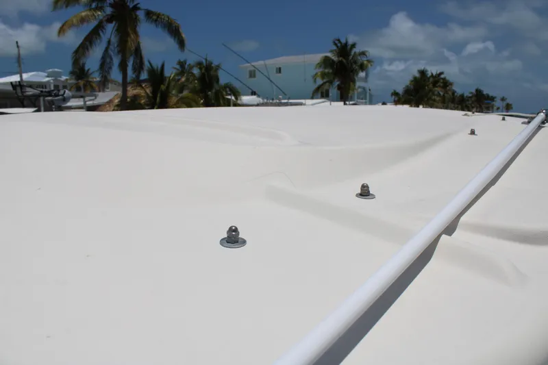 Slide: The Image of 2019 Grady-White Freedom 275 boat deck with clear sky and palm trees in background. - 37