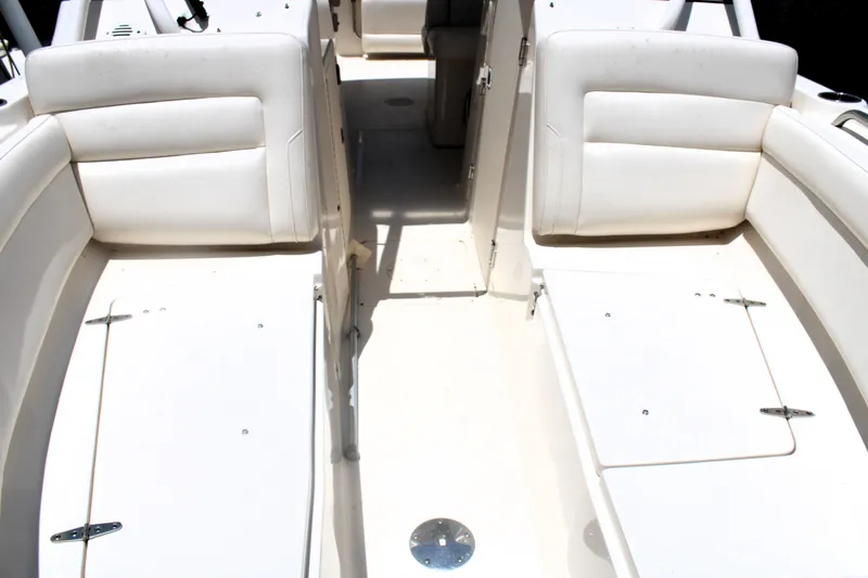 Slide: The Image of 2019 Grady-White Freedom 275 boat interior with white seating and storage compartments. - 40