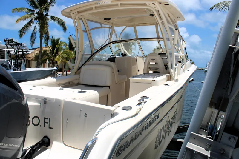 Slide: The Image of 2019 Grady-White Freedom 275 boat docked by palm trees and clear blue sky. - 5