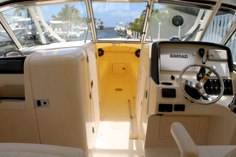 Slide: The Image of 2019 Grady-White Freedom 275 boat interior with steering wheel and navigation system. - 8